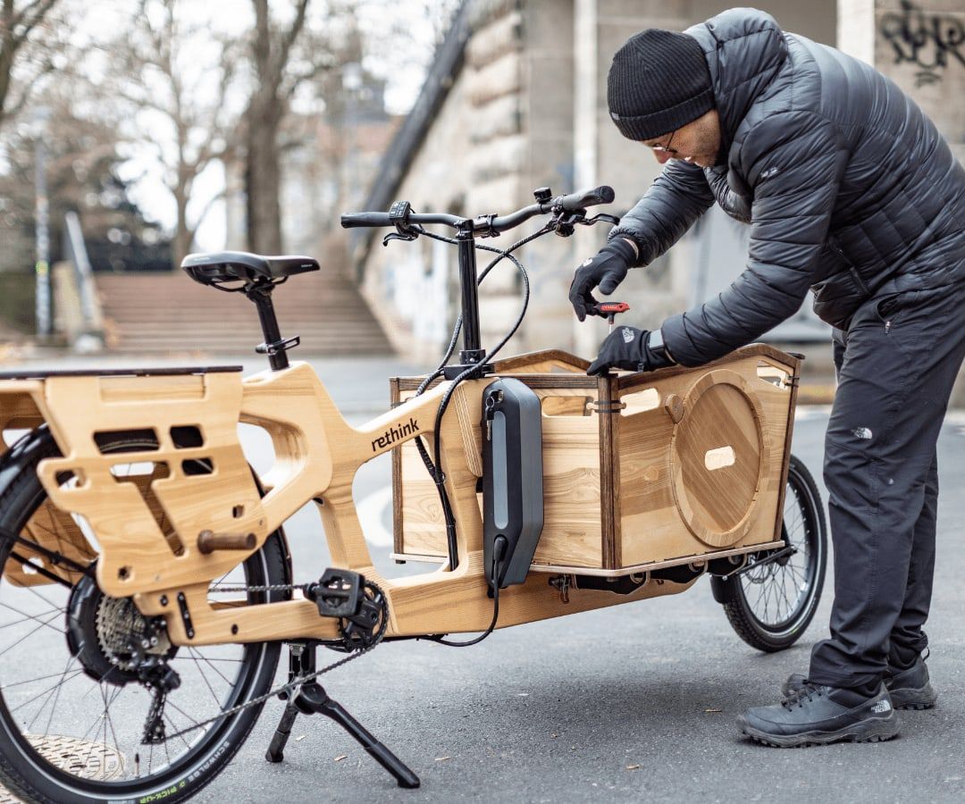 Mechaniker wartet ein Lastenrad vor Ort
